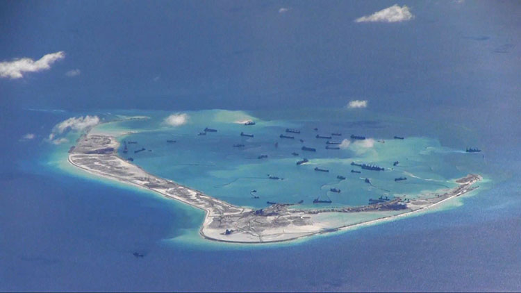 Chinese vessels artificially building up Subi Reef in the South China Sea. Photo – Commons, public domain