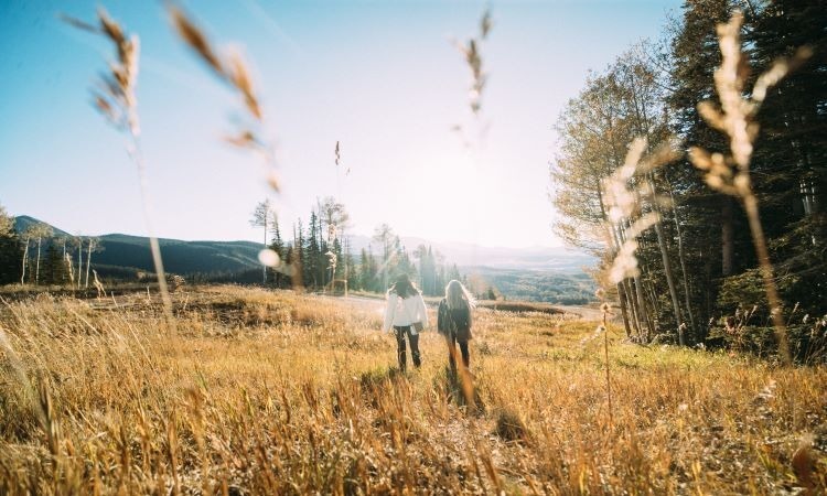 Two women walking through a field